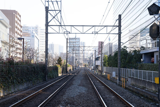 都会の線路と架線柱、まっすぐ伸びる鉄道の複線風景