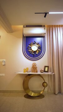 Modern luxury home interior in India. Elegant console table with Ganesha idol and wall decor.