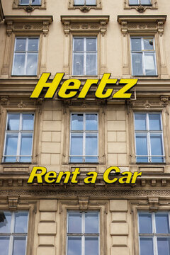 Hertz Rent a Car banner displayed on the facade of a building, Hertz is an American car rental company.
