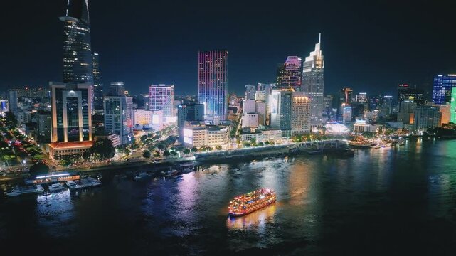Aerial View of Dinner Cruise Boat Navigating Saigon River at Night in Ho Chi Minh City, Vietnam
bright boat searchlights, colorful reflections across the water, the lit-up cable-stayed bridge