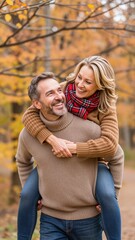 Fototapeta premium Happy couple enjoying autumn day piggyback ride in park