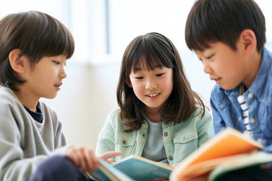 絵本を一緒に読む3人の日本人小学生
