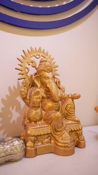 Golden Ganesha statue for home decor. Traditional Indian deity idol for spiritual worship.
