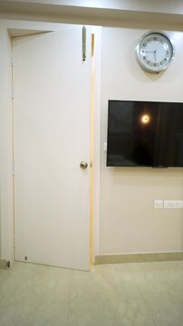 Modern bedroom interior with wall mounted television. Cozy home apartment design in India.