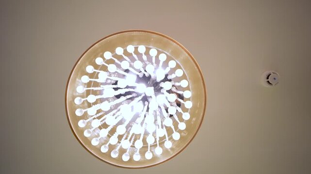 Modern ceiling chandelier light fixture. Elegant glowing lamp in a luxury interior room.