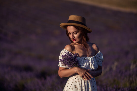Woman lavender sunset field holding flowers elegant summer dress romantic scene