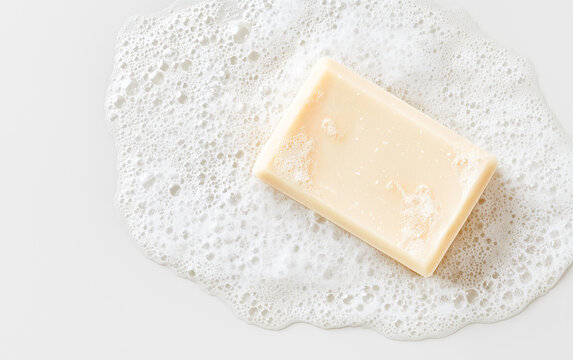 Soap bar and foam on white background, top view. Mockup for design