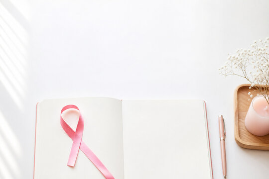 Pink ribbon on an open wellness journal, Generative AI