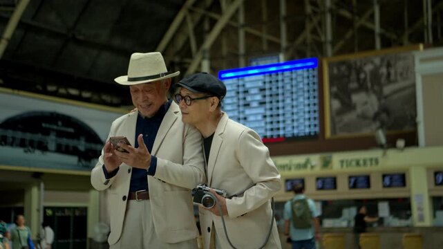 Happy senior LGBTQ couple met at Bangkok's old train station in Thailand for conversation, socializing, and a holiday