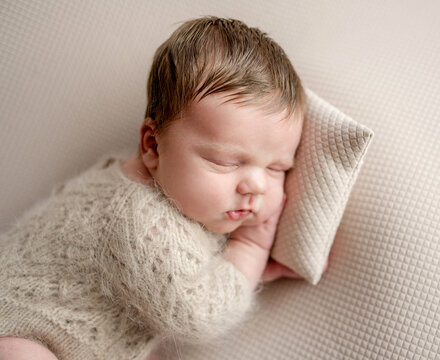 Newborn Baby Sleeping On Pillow At Newborn Photographer's Photoshoot
