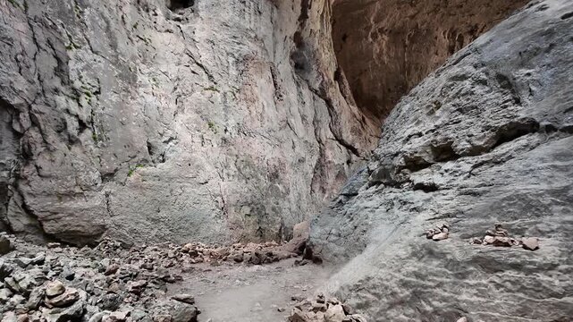 Prohodna cave eyes of god hiking POV slide forward Bulgaria tourism travel adventure massive rock formation interior geological landmark natural attraction stock video