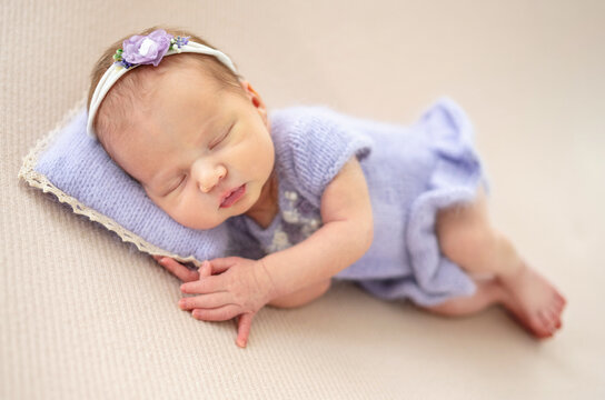 Baby Girl In A Purple Dress Sleeping During Newborn Photoshoot