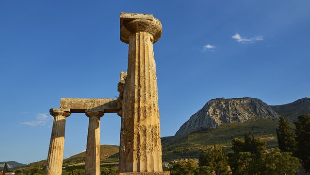 Archaic Temple of Apollo, Doric columns, Ancient columns in front of a mountain and blue sky, Archaeological site, Archea Korinthos, Corinth, Peloponnese, Greece