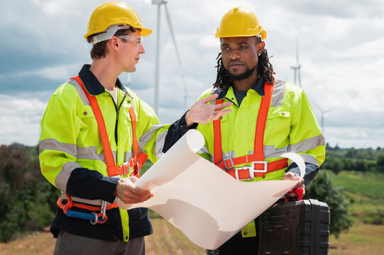 Two workers in bright safety gear stand outdoors