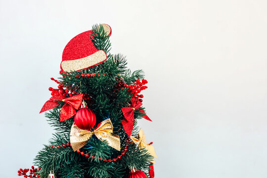 Decorative Christmas tree with red and gold ornaments on a plain background space for text