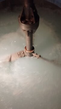 Water mixing in industrial reactor tank with agitator