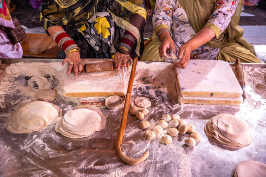 Volunteers prepare flatbreads at the Golden Temple in Amritsar, India, reflecting Sikh culture and the community service of the langar.