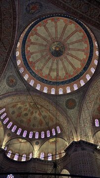 Interior view of the ornate walls and ceilings decorated with tiles and painted floral  inside the historic mosque.