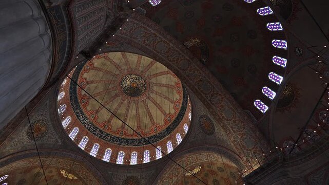 Bottom view of aged mosque dome inside. View from below on the ceiling of the mosque, camera pans and circles across the ceiling.