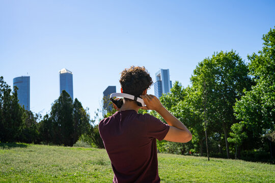 Young man with headphones with skyscrapers in the background