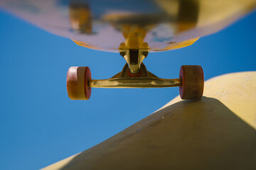 Low angle view of skateboard trucks and wheels above a skate ramp © yossarian6