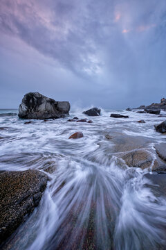A rocks on beach of fjord of Norwegian sea in winteron sunset. Utakliev beach, Lofoten islands, Norway