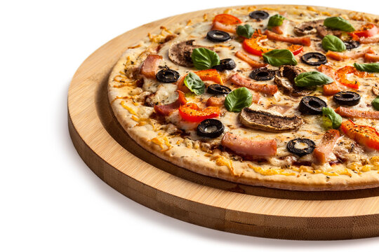A ham pizza with capsicum, mushrooms, olives and basil leaves isolated on white