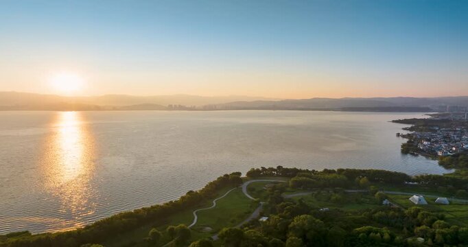 Aerial time-lapse of sunrise over Erhai Lake, Dali Yunnan, sunlight reflection on lake surface