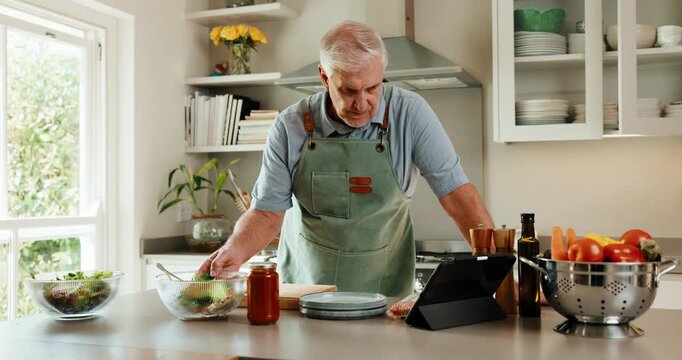 Cooking, online and senior man with tablet in kitchen, listen and watching tutorial on social media. Meal prep, tips and old person with ingredients for lunch, recipe and research with tech in house