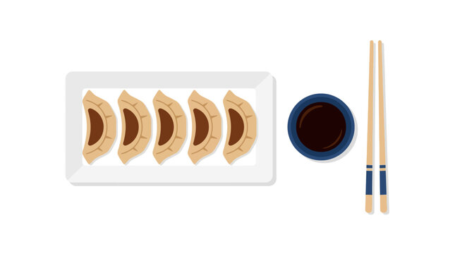 Gyoza arranged in a neat row on a rectangular white dish are paired with a bowl of sauce and chopsticks.