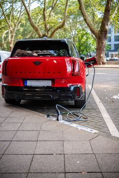 Eine E-Auto wird an einem Ladebordstein auf der K&Ouml; mit einem Kabel aufgeladen, D&uuml;sseldorf, Deutschland