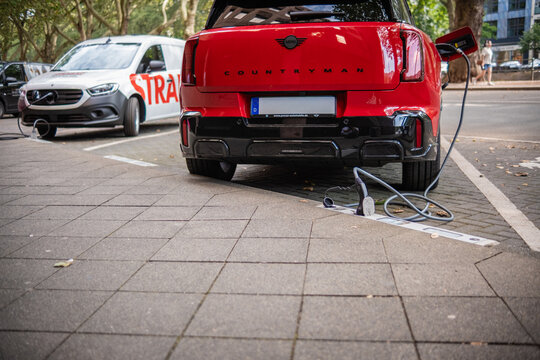 Eine E-Auto wird an einem Ladebordstein auf der K&Ouml; mit einem Kabel aufgeladen, D&uuml;sseldorf, Deutschland