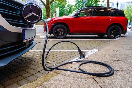 Ein E-Auto wird an einem Ladebordstein auf der K&Ouml; mit einem Kabel aufgeladen, D&uuml;sseldorf, Deutschland