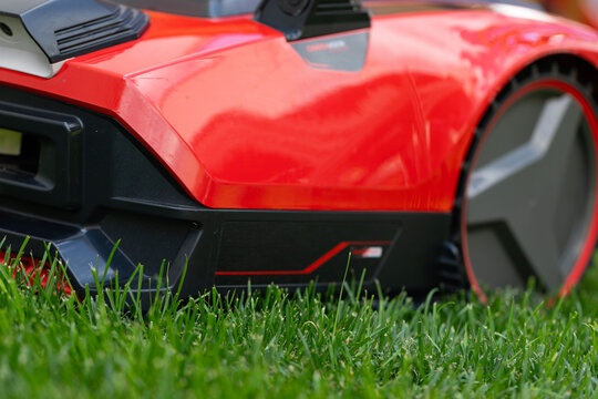 Autonomous Robotic Lawn Mower on Green Grass in a Modern Garden