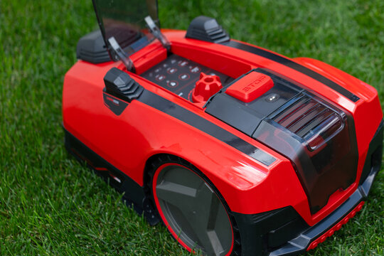 Autonomous Robotic Lawn Mower on Green Grass in a Modern Garden