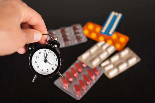 Alarm Clock and Medicine Blister Packs Representing Medication Schedule