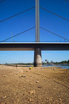 Low stream gauge of rhine river.Water shortage, drought, climate change,global warming concept, dry river bed  with skyline of the town of d&uuml;sseldorf, germany in the background