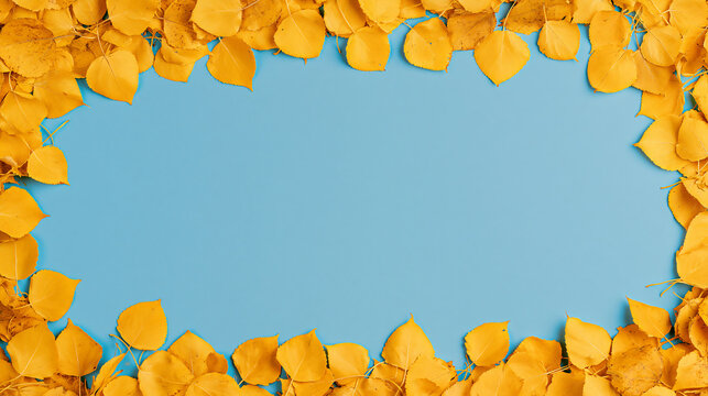 A beautiful frame made of colorful autumn leaves surrounding a bright blue background, creating a cheerful seasonal template for special designs