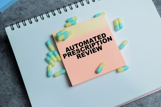 Concept of automated prescription review write on sticky notes isolated on Wooden Table.