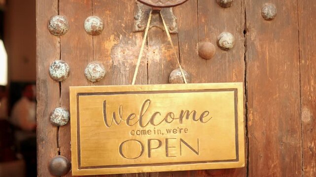 Welcome Open Sign Hanging On Rustic Wooden Door - Vintage Brass Shop Sign Inviting Customers