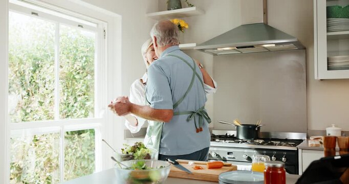 Dancing, cooking and senior couple in home kitchen with energy, bonding and love in marriage. Happy, food and ingredients for health and wellness with hug, music and people in house for retirement