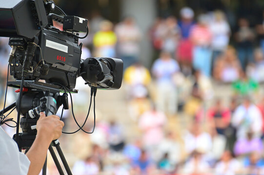 Professional TV camera broadcasting a live event with blurred crowd in the background