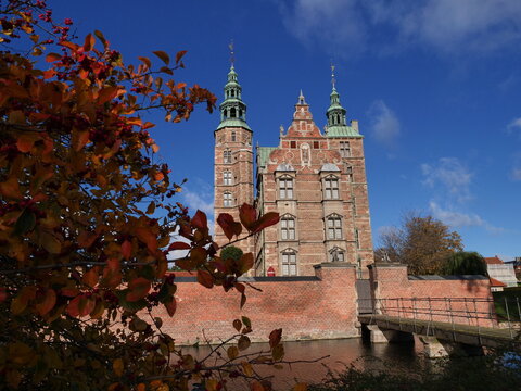Rosenborg castle in autumn season surrounded by moat and red fall leaves in Copenhagen, Denmark