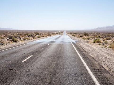 Desert Highway with Heat Wave Mirage over Empty Road