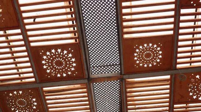 Decorative Wooden Ceiling Panels With Geometric Star Cutouts and Lattice Pergola Allowing Warm Sunlight
