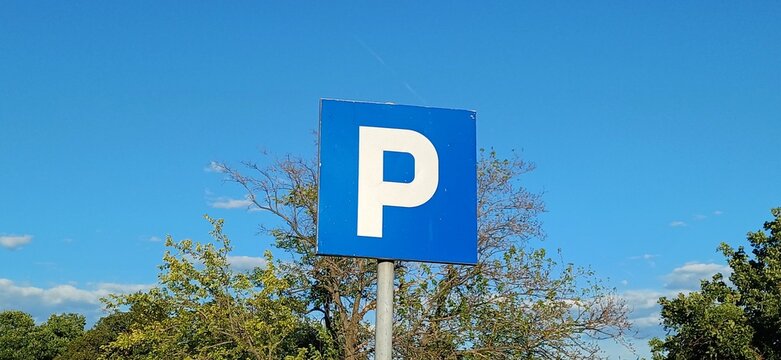 Blaues Parkplatzschild mit wei&szlig;em Buchstabe P vor klarem blauem Himmel