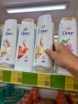 01.08.2026 Ukraine, Kharkov Woman Hand Reaching for Dove Shampoo Bottle in Supermarket