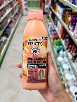 01.08.2026 Ukraine, Kharkov Woman Holding Garnier Fructis Pineapple Hair Food Shampoo