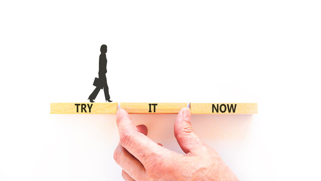 Try it now words symbol. Concept words Try is now on beautiful wooden blocks. Beautiful white background. Businessman hand. Business support motivational and try is now concept. Copy space.