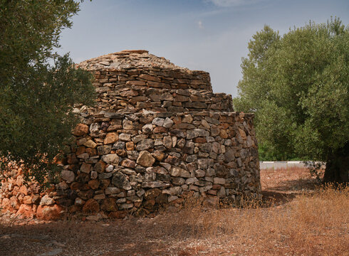 Construcci&oacute;n de piedras junto a olivos